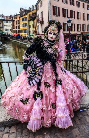 Foto de Annecy, Francia- 23 de febrero de 2013: Retrato ambiental de una persona no identificada disfrazada con un hermoso disfraz en Annecy, Francia, durante un carnaval veneciano, que se celebra anualmente, para celebrar la belleza de la verdadera Venecia - Imagen libre de derechos