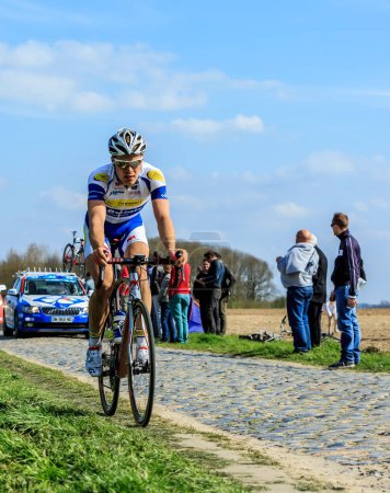 Foto de Carrefour de l 'Arbre, Francia - 12 de abril de 2015: El ciclista belga, Gijs Van Hoecke del equipo Topsport Vlaanderen-Baloise, monta en el famoso sector Careffour de l' Arbre durante la carrera París-Roubaix en 2015. - Imagen libre de derechos