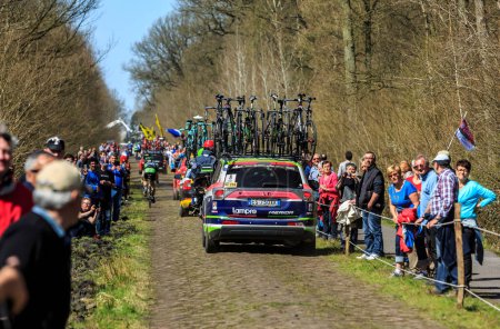 Foto de Wallers-Arenberg, Francia - 12 de abril de 2015: El coche del equipo Lampre-Mérida conduce por el famoso sector pavimentado, The Arenberg gap (Trouee d 'Arenberg), antes del paso de los ciclistas durante la carrera ciclista París-Roubaix. - Imagen libre de derechos