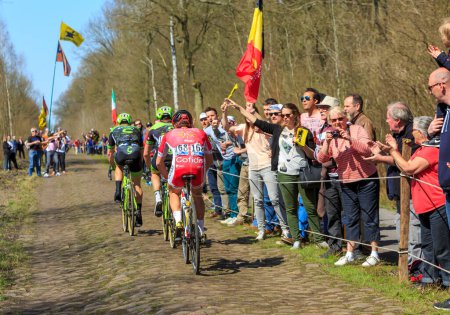 Foto de Wallers-Arenberg, Francia - 12 de abril de 2015: Vista trasera de un grupo de tres ciclistas montando en The Arenberg Gap (Trouee d 'Arenberg) durante la carrera París-Roubaix en 2015. - Imagen libre de derechos