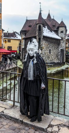 Photo for Annecy, France- February 23, 2013: Environmental portrait of an unidentified person disguised in a beautiful costume in Annecy, France, during a Venetian Carnival, which is held yearly, to celebrate the beauty of the real Venice - Royalty Free Image