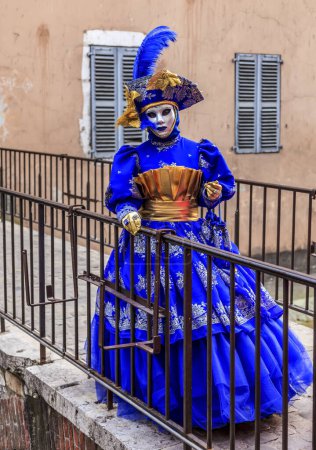 Foto de Annecy, Francia- 23 de febrero de 2013: Retrato ambiental de una persona no identificada disfrazada con un hermoso disfraz en Annecy, Francia, durante un carnaval veneciano, que se celebra anualmente, para celebrar la belleza de la verdadera Venecia - Imagen libre de derechos