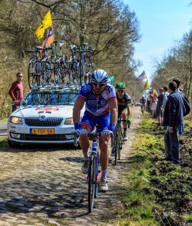 Foto de Wallers-Arenberg, Francia - 12 de abril de 2015: Dos ciclistas no identificados, cabalgan en el famoso The Arenberg Gap (Trouee d 'Arenberg) durante la carrera París-Roubaix en 2015. - Imagen libre de derechos