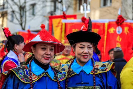 Foto de París, Francia-Febrero 25,2018: Retrato ambiental de dos mujeres disfrazadas de personajes tradicionales durante el desfile de Año Nuevo Chino 2018 en París. - Imagen libre de derechos