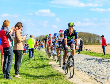 Foto de Carrefour de l 'Arbre, Francia - 12 de abril de 2015: El ciclista español, José Joaquín Rojas del Equipo Movistar, monta en el pelotón en el famoso sector Careffour de l' Arbre durante la carrera Paris-Roubaix en 2015. - Imagen libre de derechos