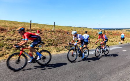 Téléchargez les photos : Côte de la Fage, France - 16 juillet 2022 : Image fleurie de trois cyclistes escaladant la Côte de la Fage dans les monts Cévennes lors de l'étape 14ème du Tour de France 2022 - en image libre de droit