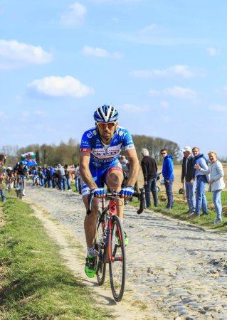 Foto de Carrefour de l 'Arbre, Francia - 12 de abril de 2015: La ciclista italiana Simone Antonini de Wanty - Groupe Gobert Team, montando en el famoso sector Careffour de l' Arbre durante la carrera Paris-Roubaix en 2015. - Imagen libre de derechos
