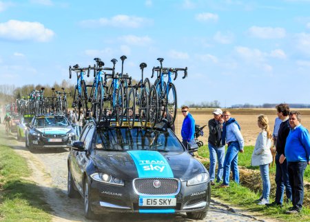 Téléchargez les photos : Carrefour de l'Arbre, France - 12 avril 2015 : La voiture de Team Sky, au volant du célèbre secteur Careffour de l'Arbre lors de la course Paris-Roubaix en 2015. - en image libre de droit