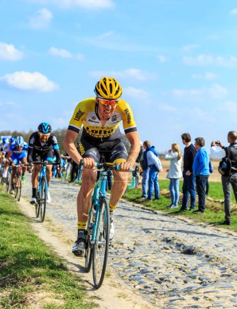 Téléchargez les photos : Carrefour de l'Arbre, France - 12 avril 2015 : Le cycliste belge, Sep Vanmarcke du Team LottoNL-Jumbo, dans le peloton sur le célèbre secteur Careffour de l'Arbre lors de la course Paris-Roubaix en 2015. - en image libre de droit