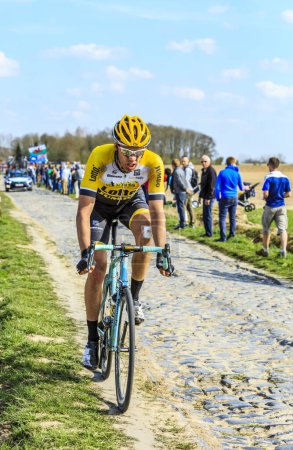 Téléchargez les photos : Carrefour de l'Arbre, France - 12 avril 2015 : Le Belge Maarten Wynants du Team LottoNL-Jumbo, dans le peloton du célèbre secteur Careffour de l'Arbre lors de la course Paris-Roubaix en 2015. - en image libre de droit