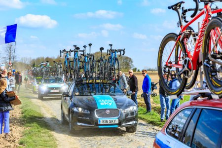 Téléchargez les photos : Carrefour de l'Arbre, France - 12 avril 2015 : La voiture de Team Sky, au volant du célèbre secteur Careffour de l'Arbre lors de la course Paris-Roubaix en 2015. - en image libre de droit
