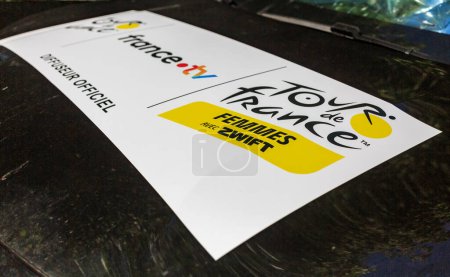 Téléchargez les photos : Culoz, France - 14 juillet 2023 : Gros plan sur un autocollant officiel publicitaire Tour de France pour femmes affiché sur une voiture lors de l'étape 13 du Tour de France 2023. - en image libre de droit