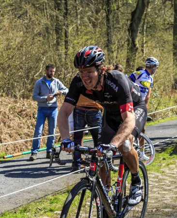 Foto de Wallers-Arenberg, Francia - 12 de abril de 2015: El ciclista herido de Nueva Zelanda Shane Archbold del equipo Bora - Argon 18, monta en The Arenberg Gap (Trouee d 'Arenberg) durante la carrera París-Roubaix en 2015. - Imagen libre de derechos
