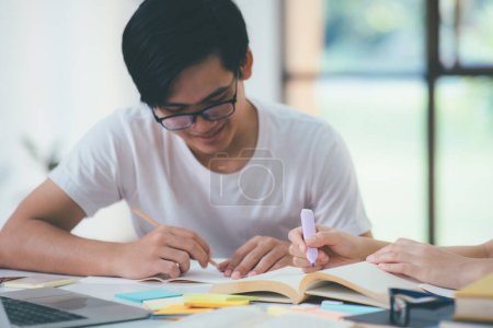 Photo for Young woman and man studying for a test or an exam. Tutor book with friends. Young students campus or classmates helps friend catching up workbook and learning tutoring in classroom, teaching, learning - Royalty Free Image
