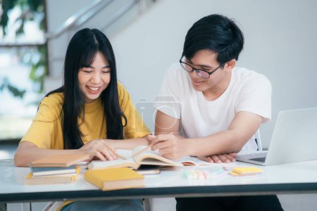 Téléchargez les photos : De jeunes étudiants asiatiques étudient pour un examen. Il y a des livres de tuteur avec des amis. Ce sont des camarades de classe qui essaient de s'entraider. Ils ont été tutorat pendant de nombreuses heures sur le campus. - en image libre de droit
