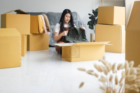 Photo for Happy single young woman packing or unpacking cardboard boxes while moving to new house or new apartment. New beginnings emotion. Living alone. Modern female people in moving home apartment leisure indoor activity alone. - Royalty Free Image