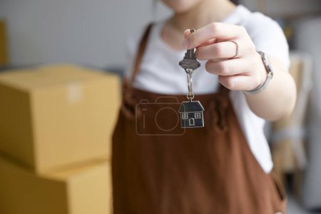 Téléchargez les photos : Crop close up of female locenter show praise house keys moving to first own new apartment or house, happy woman owner buy purchase home, relocate to dwelling, rental, rent, ownership concept - en image libre de droit