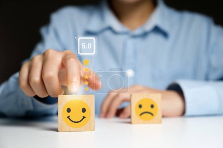 Photo for Customer satisfaction concept. Close up customer hand choose smiley face and blurred sad face icon on wood cube, Service rating, satisfaction concept.. - Royalty Free Image