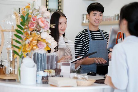 Photo for Asia Barista waiter take order from customer in coffee shop, cafe owner writing drink order at counter bar. Service mind concept. Point of Sale System, Take-out Foods, and Small Business Concepts. - Royalty Free Image