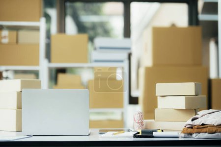 Photo for Equipments for SME online business , delivery business laptop, barcode, boxes, checking product on stocks or parcels. Small business working at home office. - Royalty Free Image