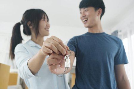 Foto de Feliz pareja joven comprando una casa nueva recibiendo las llaves. Casa propietario concepto de bienes raíces. - Imagen libre de derechos