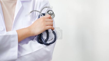 Photo for Cropped shot of an unrecognizable doctor standing with arms folded isolated on clear white hopital hall background. Copy space. medicine doctor holding stethoscope in hand wearing medical gown - Royalty Free Image