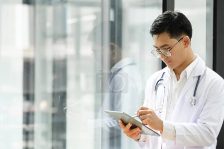 Photo for Cropped shot of a doctor using a digital tablet. Close up of doctor hands using digital tablet at clinic. Closeup of doctor in labcoat and stethoscope holding digital tablet. Doctor working on a - Royalty Free Image