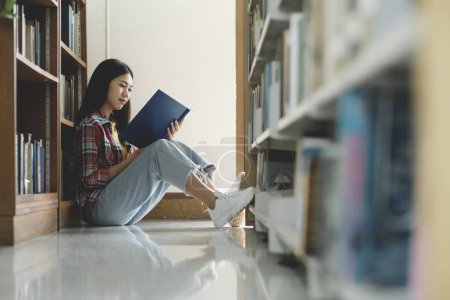 Photo for University students reading books for research and a variety of research resources in the library to support reports, assignments, papers, essays, and submissions for classes. The notion of education - Royalty Free Image