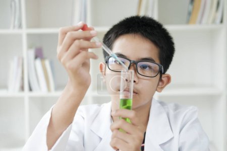 Foto de Asiático escolar primaria aprender química de la ciencia con tubo de ensayo haciendo experimento en el laboratorio de la escuela. educación, ciencia, química y concepto infantil. Desarrollo temprano de los niños. Ideal - Imagen libre de derechos
