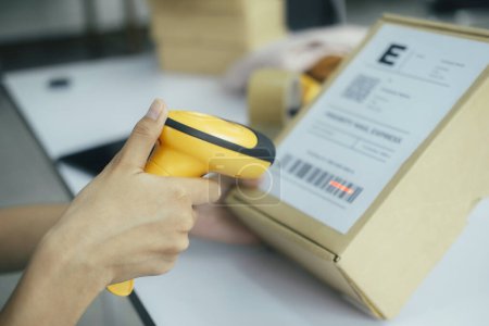 Photo for Female seller worker online store holding scanner scanning parcel barcode tag packing ecommerce post shipping box checking online retail store orders in dropshipping delivery service warehouse. - Royalty Free Image