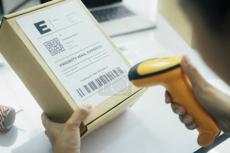 Photo for Female seller worker online store holding scanner scanning parcel barcode tag packing ecommerce post shipping box checking online retail store orders in dropshipping delivery service warehouse. - Royalty Free Image