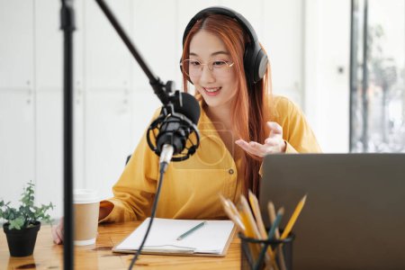 Fröhliche Frau, die einen Live-Podcast moderiert und mit dem Publikum über ein professionelles Mikrofon im Studio ins Gespräch kommt.