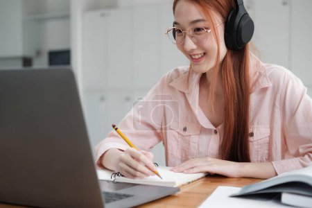 Photo for Young collage student using computer and mobile device studying online. Education and online learning. - Royalty Free Image