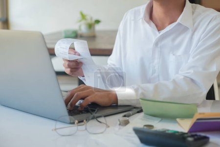 Photo for An accountant is using a computer to make calculations. and check the accuracy of accounts, calculate taxes, calculate information for investment - Royalty Free Image