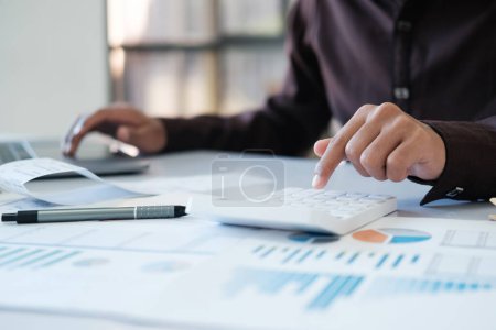 Photo for Accountants are using calculators to calculate accounts, cash bills, calculate budgets, expenses, taxes to analyze investments. - Royalty Free Image