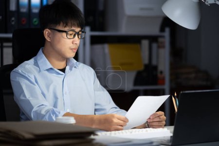 Photo for Businessman working hard overtime at night at the office. He felt tired and stressed from work. - Royalty Free Image