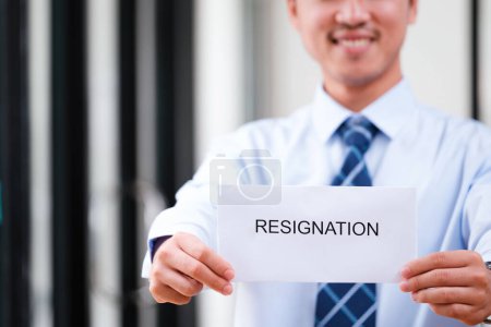 Photo for Confident Man Holding Up Resignation Letter with a Smile, Signaling a Positive Transition and Optimistic Outlook on Future Endeavors - Royalty Free Image