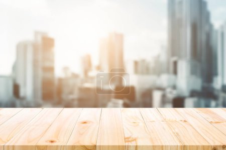 Photo for Pine wood table top overlooking a blurred cityscape, ideal for display or montage with urban context. - Royalty Free Image
