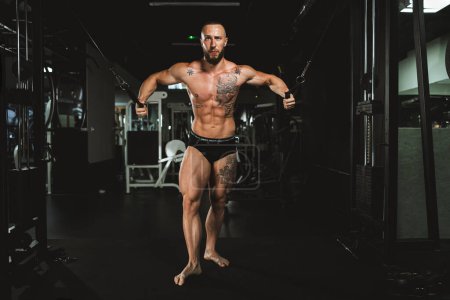 Photo for A young muscular bodybuilder man doing hard training for his chest muscles at the gym. - Royalty Free Image