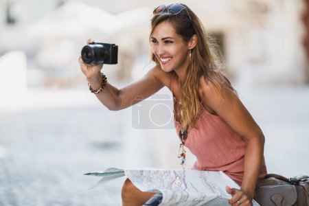Photo for Shot of a young smiling woman taking photos while exploring a foreign city. - Royalty Free Image
