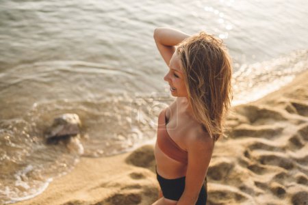 Téléchargez les photos : Une belle adolescente se tient sur la plage et profite de la mer. - en image libre de droit