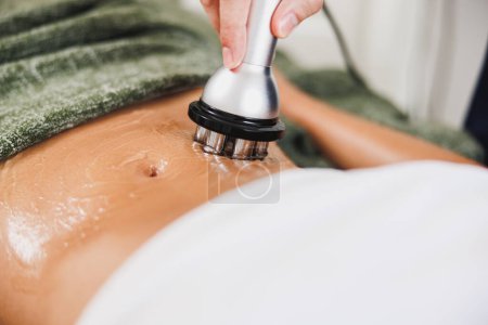 Photo for Close-up shot of a unrecognizable woman getting a RF lifting treatment on abdomen at the beauty salon. - Royalty Free Image