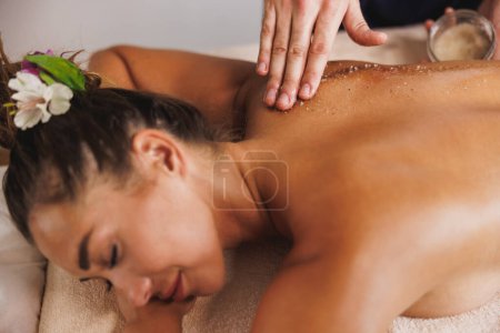 Téléchargez les photos : Plan rapproché d'une femme qui se fait masser avec du sel au salon de beauté. - en image libre de droit