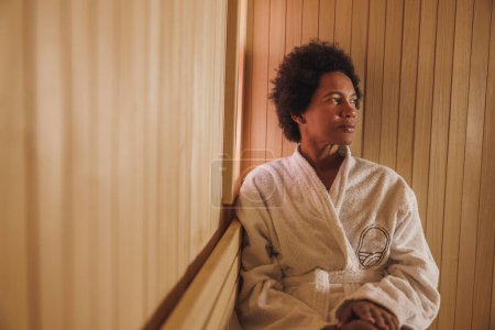 Téléchargez les photos : Belle femme mûre afro-américaine appréciant dans un sauna au centre de spa. - en image libre de droit