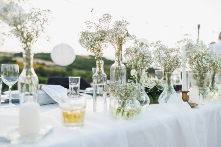 Téléchargez les photos : Table de mariage mise en place dans le style boho avec des fleurs près du vignoble. - en image libre de droit