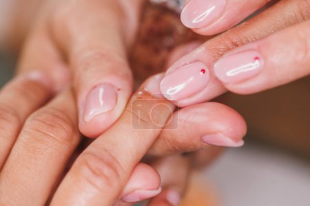 Photo for Close up of an unrecognizable therapist making cuticles treatment with oil for her female client. - Royalty Free Image