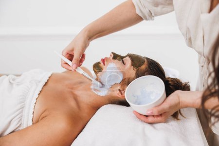 Téléchargez les photos : Belle jeune femme recevant un traitement de masque hydratant au spa. - en image libre de droit