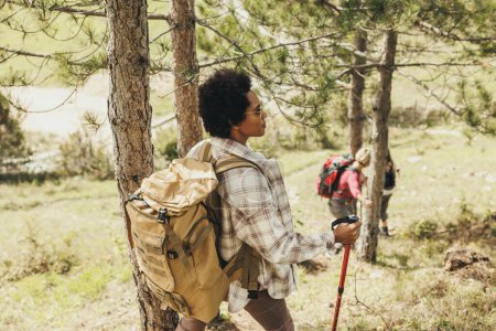 Téléchargez les photos : Mature femme noire randonnée à travers les montagnes avec ses amis. - en image libre de droit