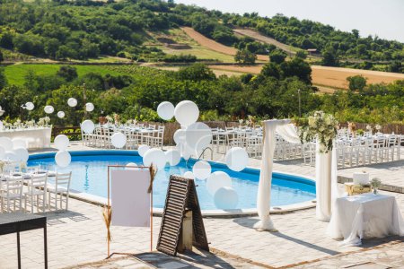 Photo for Backyard wedding setting around swimming pool with vineyard in the background. - Royalty Free Image