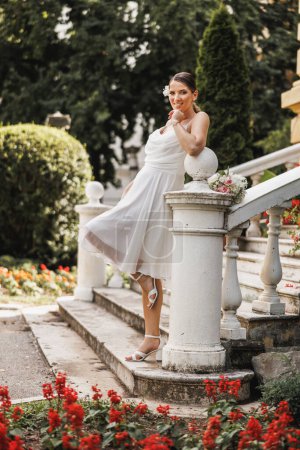 Téléchargez les photos : Mariée incroyable dans belle robe de mariée blanche posant en plein air tout en profitant de son jour de mariage. - en image libre de droit